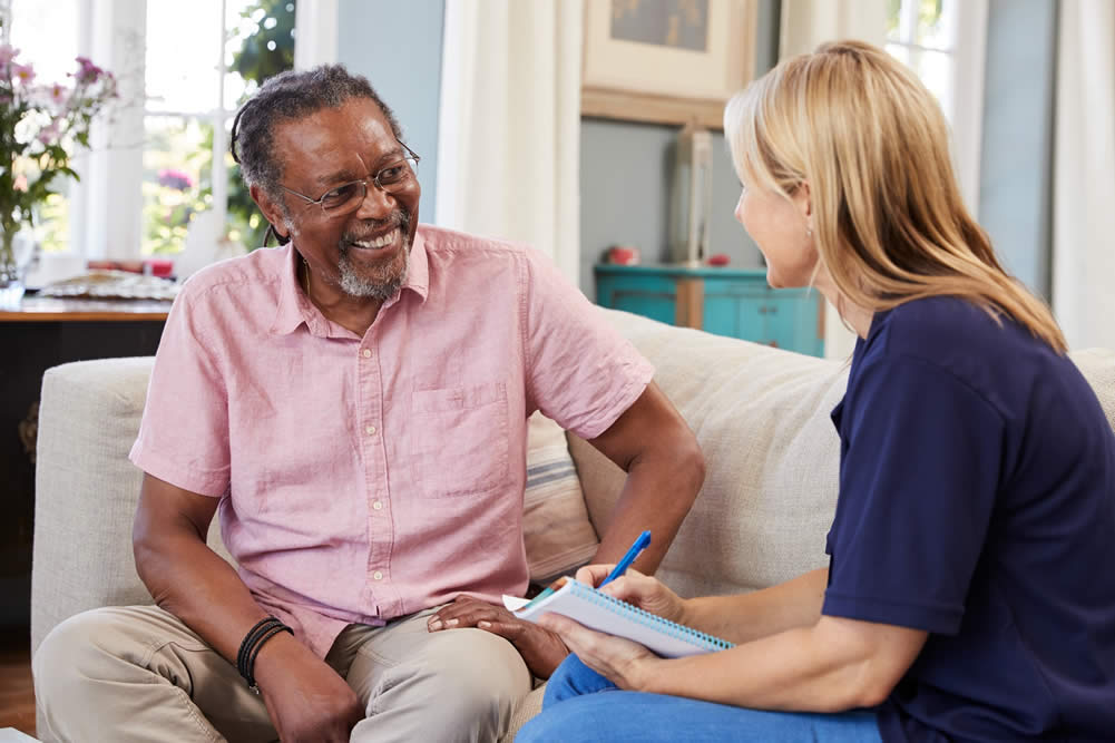 Male Senior Smiling while talking with a Caregiver