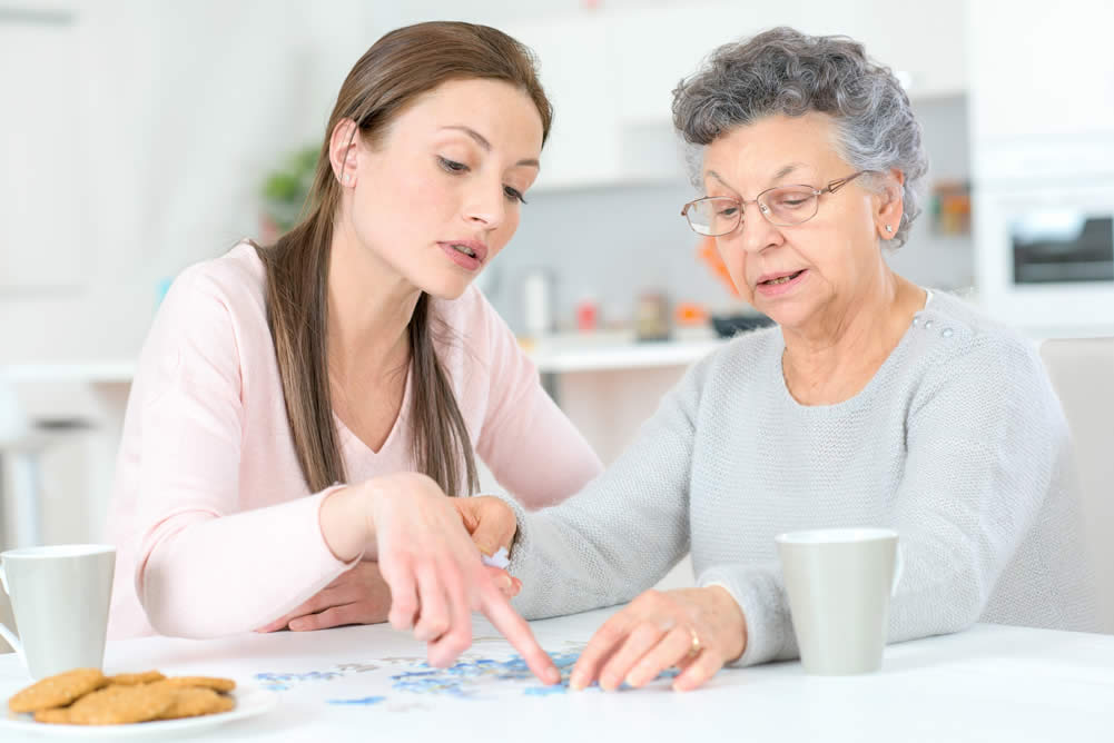 Family caregiver and senior looking at a calendar