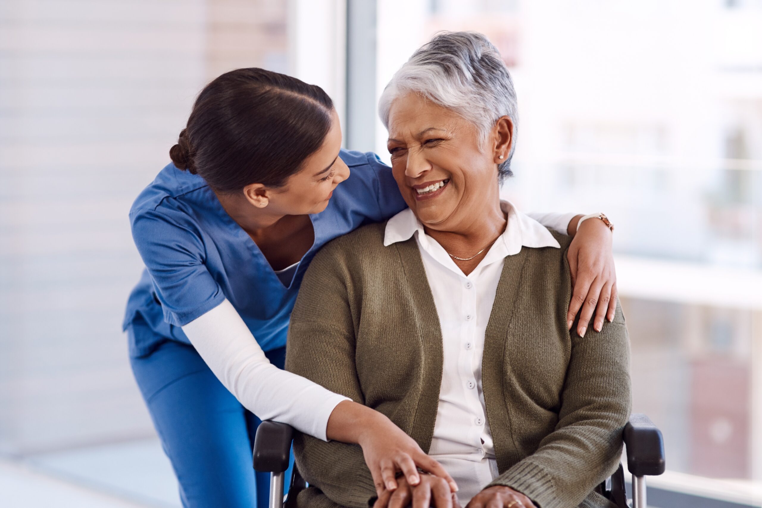 A nurse hugging an older woman